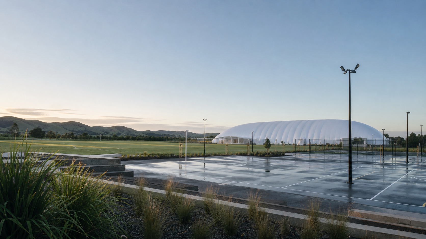 Concept visualisation — proposed community sports site with an Air Dome at first light